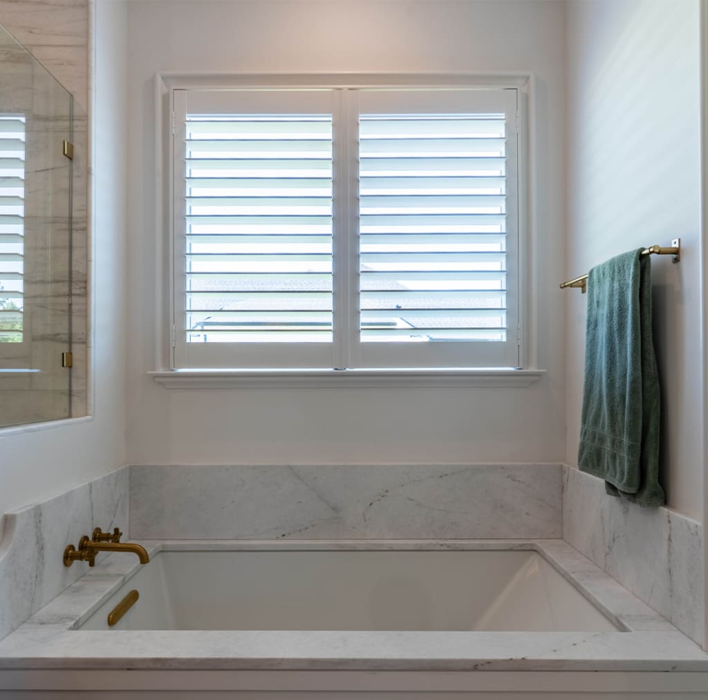 Stunning interior moveable louvered shutters installed in a bathroom. Built and installed by Dwell Shutter and Blinds