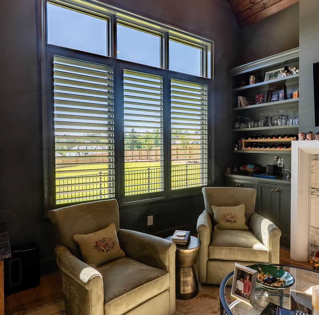 Stunning black moveable louvered shutters installed in an office space or home library. Built and installed by Dwell Shutter and Blinds