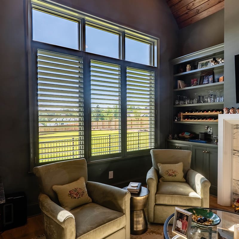 Stunning black moveable louvered shutters installed in an office space or home library. Built and installed by Dwell Shutter and Blinds