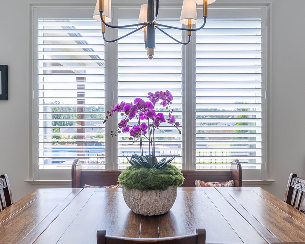 Beautiful interior louvered shutters installed in a dining room. Built and installed by Dwell Shutter and Blinds